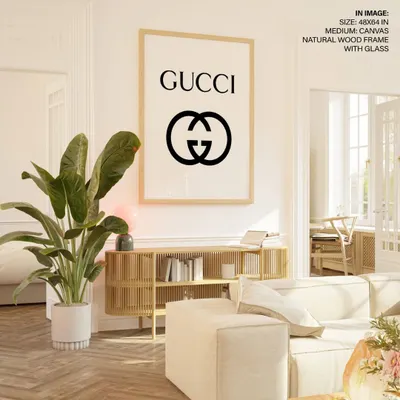 A bold and minimalist fashion statement for your wall. This Gucci logo print, displayed in a large format with a simple natural wood frame, adds a touch of high-fashion chic to a modern living space.
