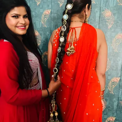 A stunning hair accessory for a bride. This long, traditional parandi is embellished with mirrors and gold tassels, perfect for accentuating a long braid.