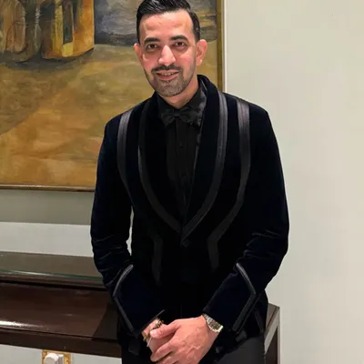Ali Baldiwala in a custom black velvet tuxedo designed for celebration. The unique lapel design adds a modern, structural element to a classic garment.