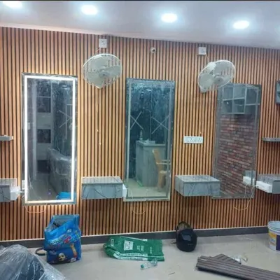 This is an in-progress look at a salon makeover in Bangalore. I used vertical wooden louver panels to create a warm, modern, and uniform look across the styling stations, providing a professional backdrop that enhances the client experience.