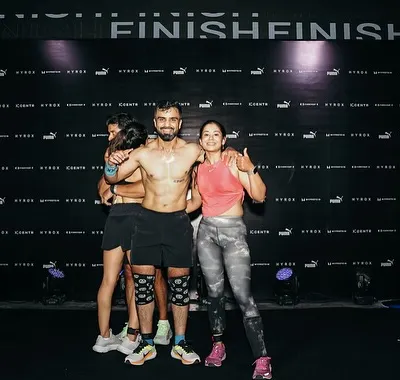 The finish line of a Hyrox race, completely spent but supported by my team. This is the culmination of months of dedicated training, a moment that shows the power of endurance and community.