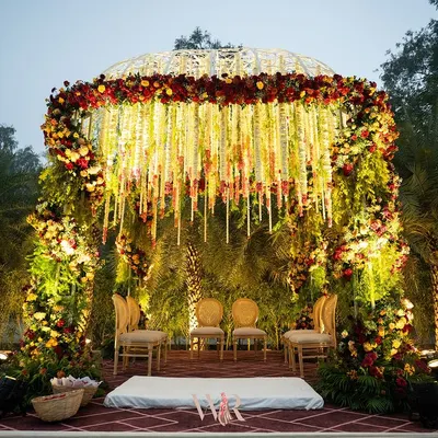 We designed this magnificent Vedi to honor timeless Indian heritage. The dome-shaped mandap, covered in a curtain of hanging white and red florals, created a sacred and breathtaking space for the couple to exchange their vows.