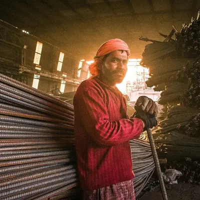 A powerful portrait of a worker, taken on location. The lighting and environment are as much a part of the story as the person's expression.