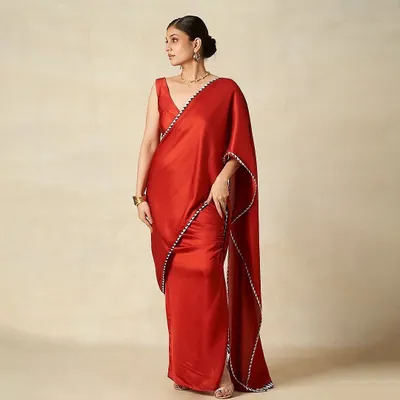 A sophisticated look for the Gulabo by Abu Sandeep campaign. The makeup is classic and elegant, with a clean low bun and a neutral palette to complement the vibrant red saree.