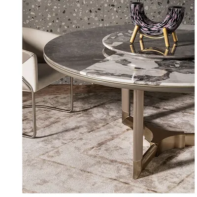A close-up of a custom dining table we crafted. The top features two types of marble for a subtle contrast, while the base is a sculptural combination of metal and leather-wrapped supports, showcasing our attention to detail.