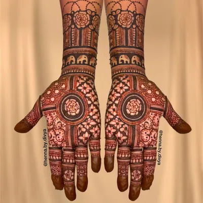 A beautiful Indian mehendi design with a central floral mandala. The wrists are adorned with bands of roses and elephants, blending different traditional elements.