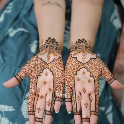 A perfect example of minimal bridal henna. This design uses negative space beautifully, with delicate leaf patterns and simple finger details for a very elegant look.