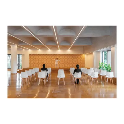 The multi-purpose hall at the Meraki Clubhouse, designed for community events and performances. We used a vaulted ceiling with integrated lighting and a patterned tile backdrop to create a space that is both elegant and functional, with excellent acoustics.