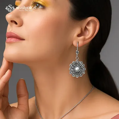 A model wears our oxidized silver floral earrings, featuring a central pearl and detailed petal work. These large drop earrings make a beautiful statement with ethnic wear.