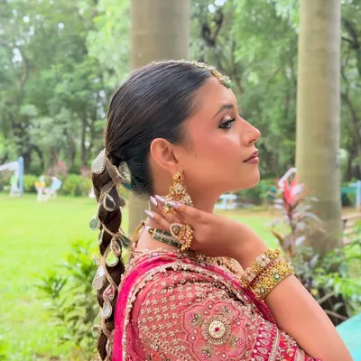 A side profile of a modern bridal look with a unique mirror-work braid.