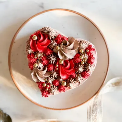 A heart-shaped cake with intricate red and chocolate piping. This is from my Valentine's Day collection, designed to melt hearts.