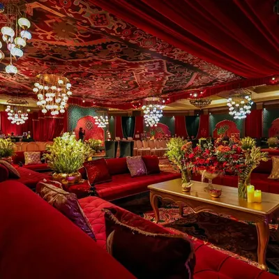 A panoramic view of the Sufi Durbar lounge, where plush velvet dewans, intricate lanterns, and layered arches create a space of intimacy and magic. The design invites guests to immerse themselves in an evening of soulful music and celebration.