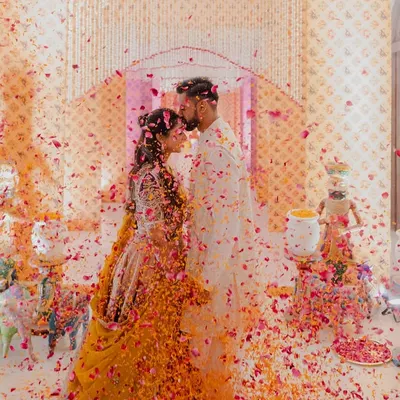 A magical moment from a Garba night, where the couple is showered in a rain of colorful petals. The decor, featuring traditional motifs and floral arrangements, created the perfect backdrop for this joyous celebration.