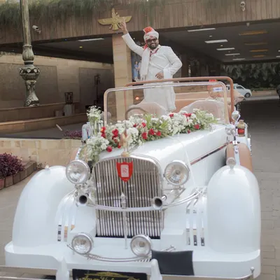 Making a statement with a grand entry in a vintage car. This is a classic and stylish way for the groom to arrive for his South Indian wedding.