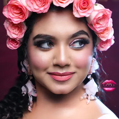 A close-up of a whimsical, fairy-tale look perfect for a Christian wedding or reception. The fresh rose flower crown and soft pink makeup create a romantic and dreamy vibe.