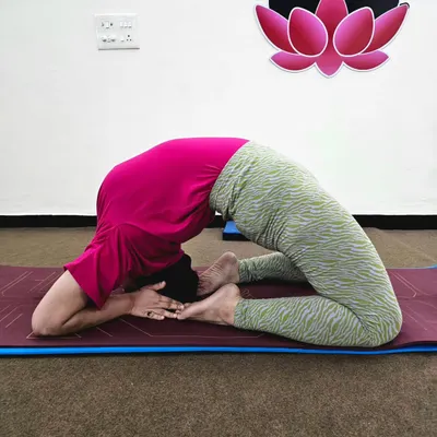 A student demonstrates an advanced variation of Kapotasana (Pigeon Pose). This deep backbend requires significant flexibility in the spine and shoulders, which we build progressively.