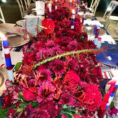 The brief for this event was a "London theme evening," so I went with a dramatic, monochromatic red tablescape. The dense floral runner, accented with custom candles, created a bold and sophisticated atmosphere for the dinner party.