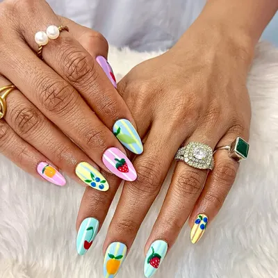 A fruity fiesta for your fingertips. This fun and colorful set features a mix of pastel-striped nails, each adorned with a different hand-painted fruit like strawberries, cherries, and oranges.