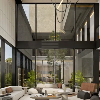 Another view of the 'House of Courtyards' living room, where soaring ceilings and floor-to-ceiling windows create a breathtaking sense of volume. The space is designed to feel both grand and intimately connected to the central green courtyard.