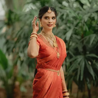 An elegant portrait of a South Indian bride. Her makeup is kept classic and clean to let the beautiful silk saree and traditional gold jewelry take center stage.