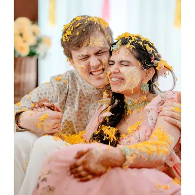 A moment of pure, messy joy. We love capturing the couple lost in laughter during the haldi ceremony, a memory that's as golden as the turmeric itself.