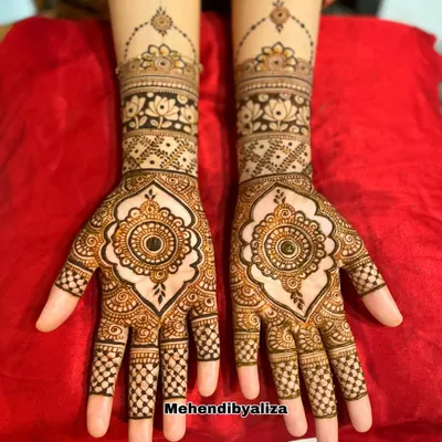 A designer creation featuring a beautiful mandala at the center of the palm. The look is completed with lotus motifs and checkerboard patterns on the fingers.