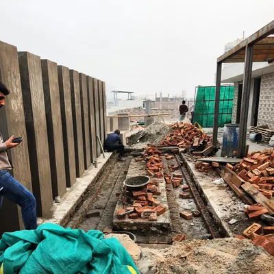 The initial construction phase of a terrace water body. This image shows the groundwork and brickwork being laid out before the finishing materials are applied.