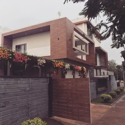 A bungalow we designed for an industrialist in Hubli, featuring a bold, modern aesthetic. The exterior is defined by strong horizontal lines, cantilevered structures, and a material palette of Fundermax panels and textured plaster.
