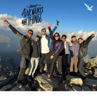 Collect adventures, not things. A happy group posing on a mountain top after a successful trek.