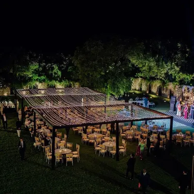 A breathtaking wide-angle view of an outdoor reception at Alila Fort. The guest seating is arranged under a massive canopy of fairy lights, creating a starlit sky effect for a truly magical evening.