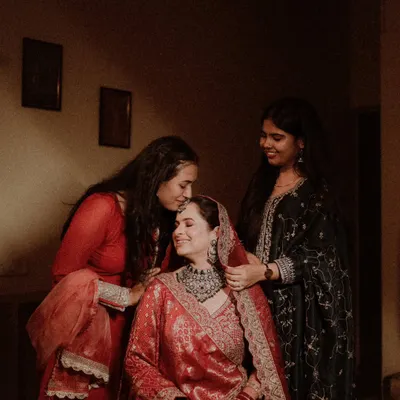 The precious bond between a bride and her sisters. This heartwarming photo captures a tender moment as they help her get ready.