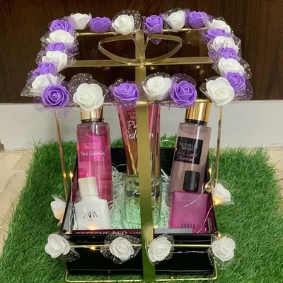 A stunning fragrance hamper designed for someone special. This elegant metal basket is filled with a collection of perfumes and body mists, and decorated with beautiful purple and white roses.