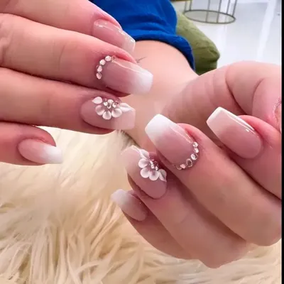 The quintessential bridal nail set. This design features a soft baby boomer ombré on square extensions, adorned with exquisite 3D white flowers and sparkling crystals.
