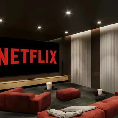 A simple yet effective home theater setup with a large screen and comfortable red sofas. The dark walls and minimalist design ensure an immersive, distraction-free viewing experience.