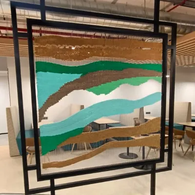 A close-up of the finished tapestry installation for a corporate office in Hyderabad. The woven textures of coir and thread create a warm, organic feel, contrasting beautifully with the modern office environment.