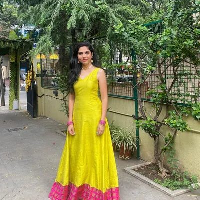 This full-length gown is crafted from vibrant yellow raw silk. I added a contrasting pink brocade border at the hem to give it a traditional touch while keeping the silhouette modern and clean.