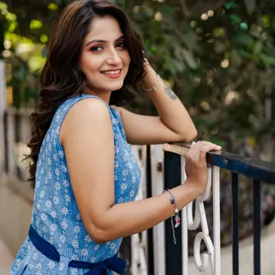 A bright and engaging outdoor portrait of an actress. Her warm smile and relaxed pose against the railing create a friendly and approachable headshot, perfect for her portfolio.