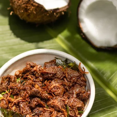 This is my signature Beef Ullarthu, a staple in any Syrian Christian home. I slow roast beef in a spicy, aromatic masala with coconut chunks and curry leaves until it's incredibly flavourful. It's a fantastic starter or side dish for any meal.