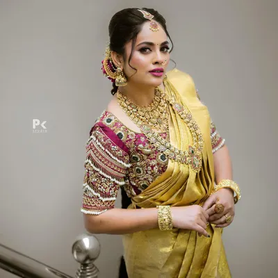 This is the quintessential South Indian bridal look I specialize in. The set features intricate temple jewelry with a matte gold finish, including a detailed choker, a longer kasina sara (coin necklace), matching jhumkas, and a maang tikka, all coordinated to create a regal and timeless appearance for the main wedding ceremony.