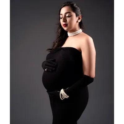 A different angle from the glamorous maternity shoot. The classic makeup with a bold red lip and soft waves creates a timeless and sophisticated portrait.
