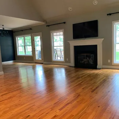 This spacious living room features a glossy, medium-toned hardwood floor that I installed to bring a sense of warmth and tradition. The polished finish reflects light beautifully, making the entire space feel grand and inviting.