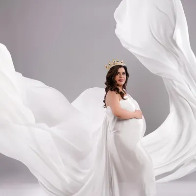 A powerful and graceful portrait of a mother-to-be, crowned and draped in flowing white fabric. This shot is all about celebrating the queen you are.