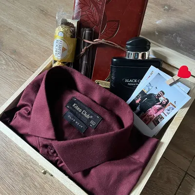A classic and sophisticated custom hamper for him. This wooden box contains a stylish maroon shirt, a personalized journal, a premium pen, perfume, and a polaroid photo to capture a special moment.