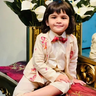 For this kids' couture shoot, I styled this young model in a charming cream-colored suit with delicate floral embroidery on the jacket and a patterned bow tie for a pop of color.