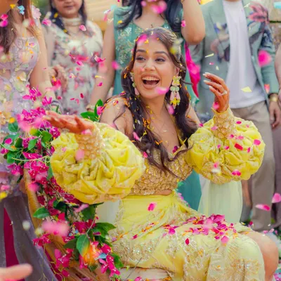A bride's infectious laughter as she is showered with flower petals during her 'phoolon ki holi'. This is the kind of vibrant, joyful, and unscripted moment we love to capture.