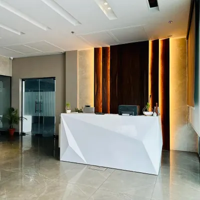 A wide view of the reception area I designed in Ambala, showcasing the geometric desk, back-lit wood paneling, and polished flooring that combine to create a modern and impressive entrance.