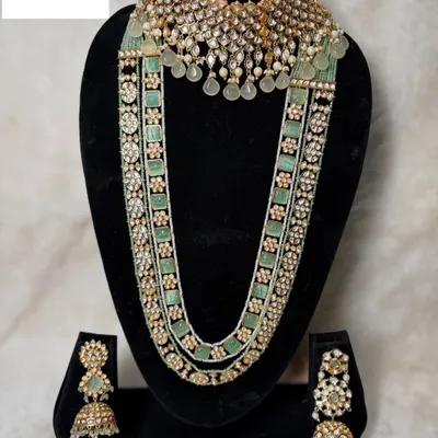 Set B-19 is a masterpiece in pastel green. It features a wide polki choker and a multi-strand long haar with pearl and stone detailing, perfect for a modern bride.