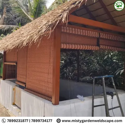 A completed premium cow shed with a traditional thatched roof and bamboo blinds for ventilation. This structure at Mother India Farming Pvt Ltd is designed to be both functional and aesthetically pleasing.
