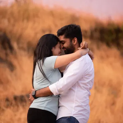 An intimate embrace, with foreheads touching, is a powerful symbol of connection. This close-up from a pre-wedding shoot captures the deep bond and quiet affection between the couple, set against a soft, natural background.