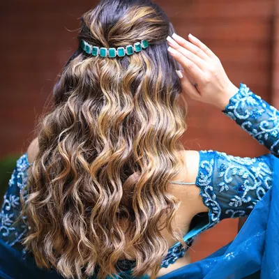 Beautiful, bouncy curls with a lovely shine. This half updo is accented with an elegant green hair clip, perfect for a reception or cocktail event.